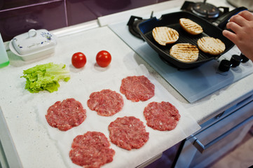 Сooking burgers in the kitchen at home during quarantine time.