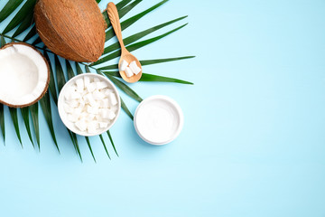 Organic cosmetics with coconut on blue background top view. Skincare, body treatment concept.