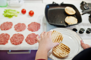 Сooking burgers in the kitchen at home during quarantine time.