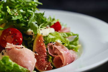 Salad with ham, figs and vegetables.