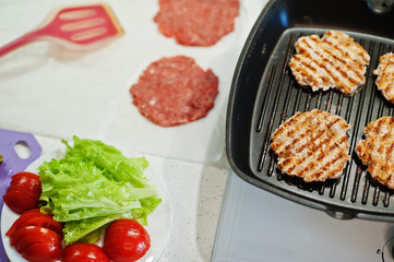 Сooking burgers in the kitchen at home during quarantine time.