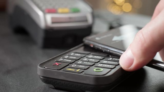NFC Technology. The user makes contactless payment by mobile phone. Launches a smartphone to the pos terminal or credit card machine of cashless payment. Wireless payment nfc lifestyle.
