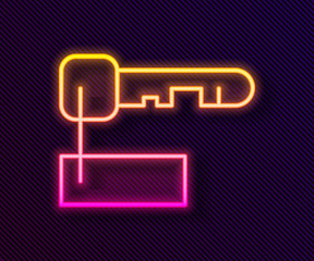 Glowing neon line Marked key icon isolated on black background. Vector Illustration