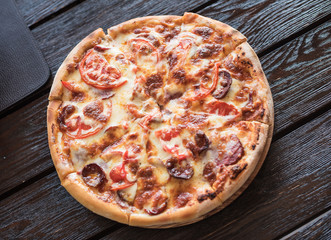 Big tasty sausage and tomatoes pizza. Traditional Italian dish