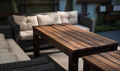 Recreation area on a verandah. A table and a sofa with pillows