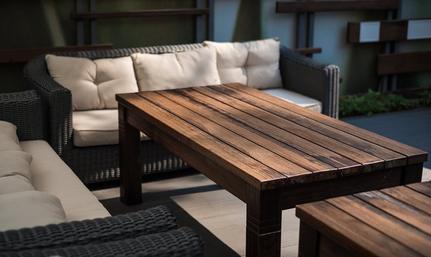 Recreation area on a verandah. A table and a sofa with pillows