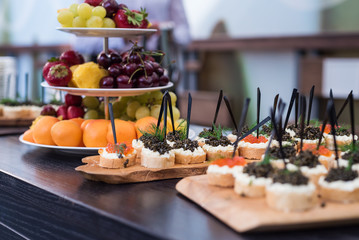 Beautiful snack and bright fruit on a table. A tasty entertainment for guests