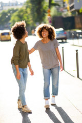 Full length two black female friends walking in city