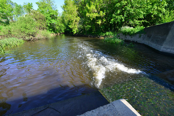 Obraz premium Water flowing through a Weir on the river Mole in May 2020