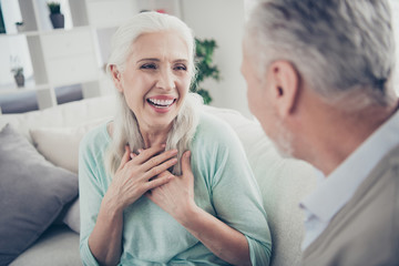 Obraz premium Photo of laughing aged pair speaking funny humorous stories sitting cozy sofa indoors