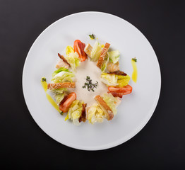 Ceasar salad with bacon served on a white plate