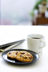 cup of hot black coffee on white table background with notebook and stationery.  Work from home concept.