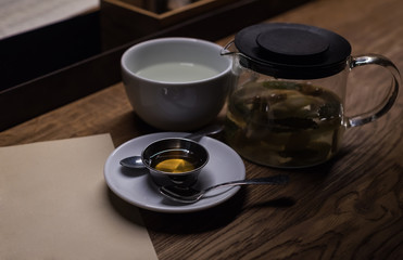 White cup. honey and tea in a scalded teapot. A cup of tasty tea in cafe