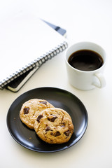 cup of hot black coffee on white table background with notebook and stationery.  Work from home concept.