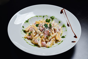 Creamy pasta with pesto on plate.