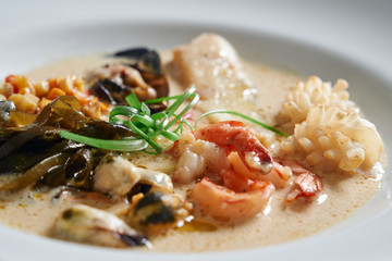 Plate with different seafood on table.