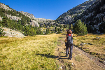A young woman walking in the valley going up from Baños de Panticosa in the Aragonese Pyrenees....