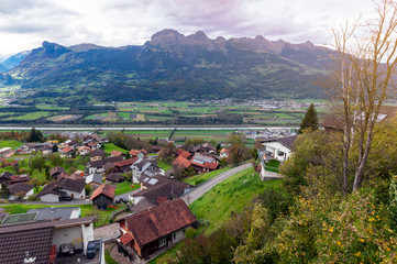 Fototapeta premium Scenic aerial view of hillside villages in Triesenberg and the river Rhine, natural border of Liechtenstein, an alpine country in central Europe, to Switzerland