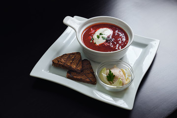 Delicious ukrainian borsh on plate with bread.