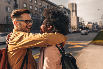 Smiling couple enjoying on vacation, young tourist having fun walking and exploring city street during the day.