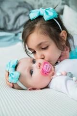 Girl kisses her newborn sister. - 346137351