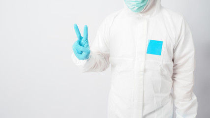 male model in PPE suite doing good luck hand sign on white background.