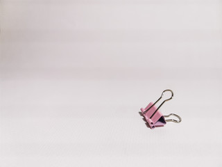 Fototapeta premium Pink paper clip on a white background. Office stationery. Space for your text.