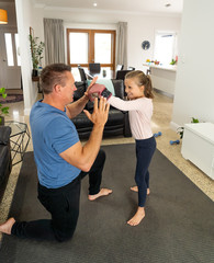 COVID-19 Outrbreak. Father and daughter exercising together at home during coronavirus quarantine