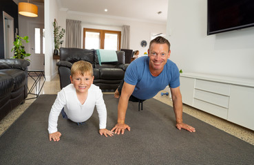 COVID-19 Outrbreak. Father and son exercising together at home during coronavirus quarantine