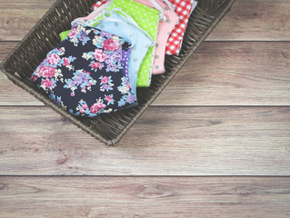 colorful fabric mask in rectangle basket on wooden table.protection from coronavirus or covid-19 , new normal lifestyle concept.
