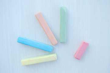 Colorful chalk scattered on a white background.