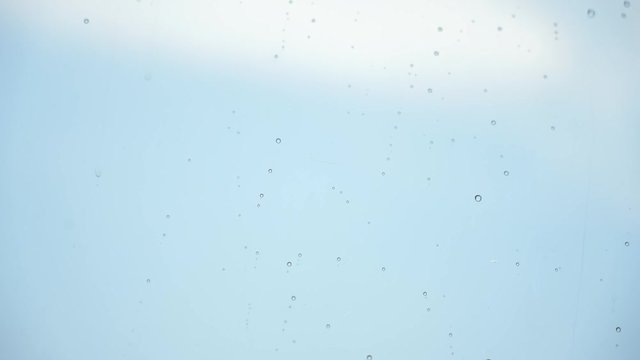 Drops of rain trickling down on black background isolated. Droplets of water on black glass background running down. 4K Stock Footage shot on high speed camera.