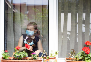 Little girl looking out the window. Coronavirus pandemic, stay ay home concept.