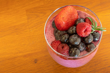 Mixed berries smoothie on wooden table