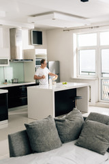 selective focus of man pouring milk in bowl with cornflakes near apples