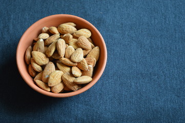  almonds in bowl on a black background
