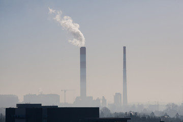 Dirty air or smog on the backdrop of an industrial city with factories, houses and churches or smoke that erupts from the pipe