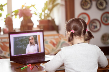Study online with video call teacher. Young girl learn online and looking at laptop at home.Social distancing.