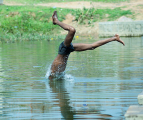 Boy diving in a river in India to bathe