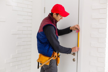 Young repairman adjusting a terrace door handle with screwdriver