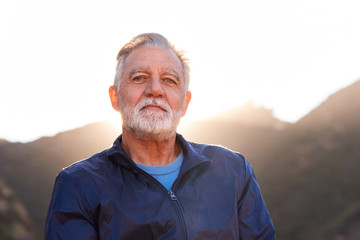 Outdoor Portrait Of Serious Hispanic Senior Man With Mental Health Concerns In Countryside