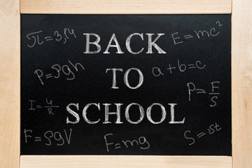 Blackboard with text written in chalk back to school and formulas.