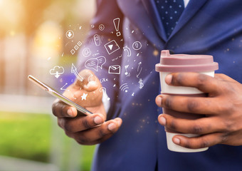 African businessman holding coffee and using brand new mobile phone