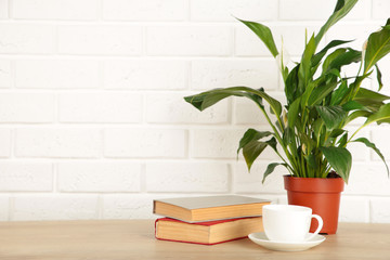 Working table with coffee cup, books and houseplant. Stay home