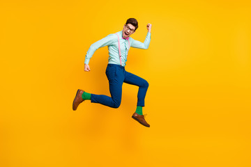 Fototapeta na wymiar Full size profile photo of cool stylish guy jumping high up rejoicing winner wear specs shirt bow tie suspenders trousers shoes green socks isolated bright yellow color background