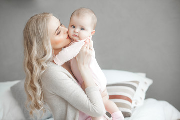 Young mother with little baby. Mommy holding her cute child. Maternity concept.