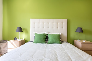 Modern bedroom in white and green colors. European hotel design and inside.