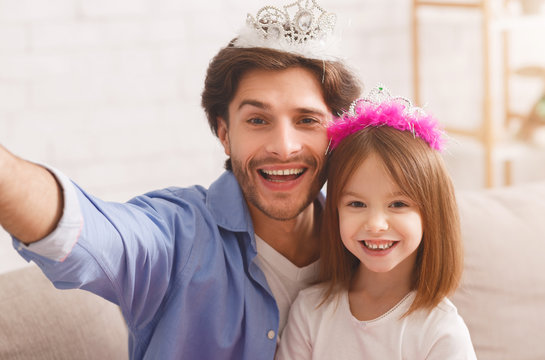 Portrait of pretty little princess and her father wearing crown
