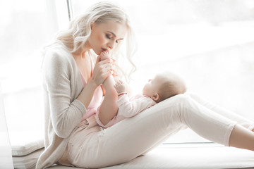 Young mother with little baby. Mommy holding her cute child. Maternity concept.