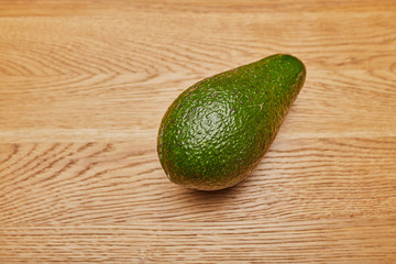 green avocado on a wooden table
